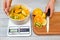 Woman`s hands weighing sliced fruits