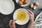 Woman& x27;s hands whisk eggs in bow. Cooking omlette for breakfast. Top view, flat lay of cooking process. Dark background