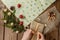 Woman s hands wrapping Christmas gift, close up. Unprepared christmas presents on wooden background with decor elements and items