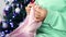 Woman's hands with yarn are knitting handmade wool clothes against the background of the Christmas tree close-up