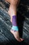 Woman`s leg with kinesio patch on ankle and foot
