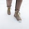 Woman`s legs in fashionable pants in stylish winter brown leather boots on the backdrop of snow. Fashion girl walk outdoors.