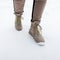 Woman`s legs in fashionable pants in stylish winter brown leather boots on the backdrop of snow. Fashion girl walk outdoors. Clos
