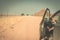 Woman`s legs leaning out from car standing on gravel road in the Namib desert, Namib Naukluft National Park, main travel destinati