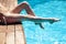 Woman`s legs over pool water