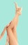 Woman`s legs with smooth skin after depilation on pastel background.