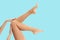 Woman`s legs with smooth skin after depilation on pastel background.