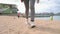 Woman's legs in sneakers close-up, going to the front of the camera. Dolly shot. Walking along the sandy beach