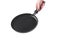 Woman\\\'s light-skinned hand is holding a frying pan