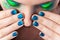 Woman\'s lips with beautiful multicolor Minx nails and make-up