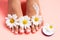 Woman`s perfect, groomed feet with of natural herbal cream. Love a feet. Beautiful flowers on pink background. Care about clean,