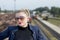 The woman\'s portrait in sunglasses against railway tracks