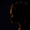 Woman\\\'s profile in shadow with reflections of golden light