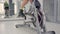 Woman`s reflection in the mirror in tracksuit on a stationary bike. Legs are spinning pedals on the stationary bicycle.