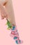 Woman`s unshaven leg in pink socks with dinosaurs on a pink background. Pink flowers is in the socks