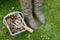 Woman\'s winter boots next to a basket of autumn leaves