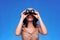 Woman in safari hat looking through binoculars