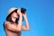 Woman in safari hat searching with binoculars