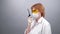 Woman in safety glasses, medical mask and rubber gloves speaks on the walkie-talkie or talking on a portable radio set