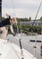 Woman on sailboat with boat hook grabbing rope for mooring ball