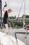 Woman on sailboat with boat hook grabbing rope for mooring ball