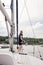 Woman on sailboat with boat hook preparing to dock boat