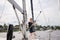 Woman on sailboat with boat hook preparing to dock boat