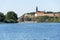 Woman sailing on standup paddleboard on Vltava river with Vysehrad in background in Prague, Czech Republic