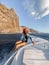 Woman sailing on a yacht near rocky shore