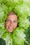 Woman with salal leafes around her head.