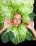 Woman with salal leafes around her head.