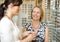 Woman With Salesgirl Selecting Glasses In Store