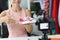 Woman salesman consultant shows to camera red sports shoes