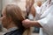 Woman in salon and hairdresser with a hairdryer