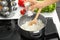 Woman salting boiled rice in kitchen