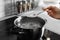 Woman salting boiling water in pot on stove