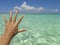 Woman saluting with open hand a tropical beach