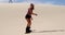 Woman sand boarding while man watching her 4k