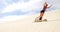 Woman sand boarding on the slope in desert 4k