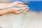 woman with sand falling through her hands