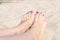 Woman sandy feet with blue nails pedicure