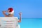 Woman in Santa Claus Hat show gesture Okay on sunbed at beach with turquoise sea view