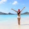 Woman In Santa Hat And Bikini on Beach Christmas