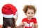 Woman in santa hat gives to girl a gift. the child accepts a gift box from mom. baby in New Year`s holiday clothes. Christmas