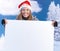 Woman in santa hat holding huge letter smiling