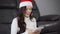 Woman in santa hat using digital tablet in living room