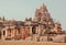 Woman in sari walking past walls of the 7th century Hindu temples, India. Architecture of Pattadakal