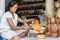 A woman is saturating with stain wooden Buddha