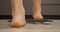 Woman on scales. Female stepping on weighing scales. Feet measuring body weight or overweight, close up. Legs checking body weight