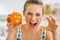 Woman scaring with orange with hallowing face